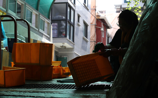 지난 8월 집중호우 이후 침수된 서울 신림동의 한 부품업체 관계자가 반지하 창고에서 물품을 꺼내 세척하고 있다. [사진=뉴시스]