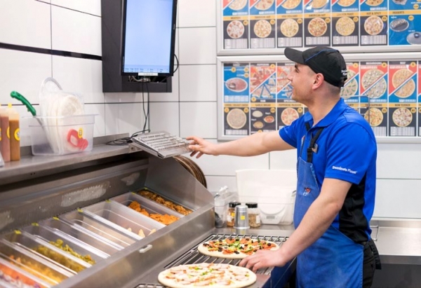 한 도미노 직원이 주문 받은 음식을 준비하고 있다. 고객들은 도미노의 피자 트래커 서비스를 매우 좋아한다.