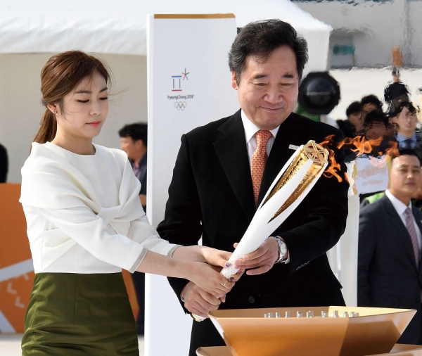 슬롯사이트동계올림픽 성화 도착 환영행사에서 김연아와 이낙연 국무총리가 성화대에 성화를 점화하고 있다.