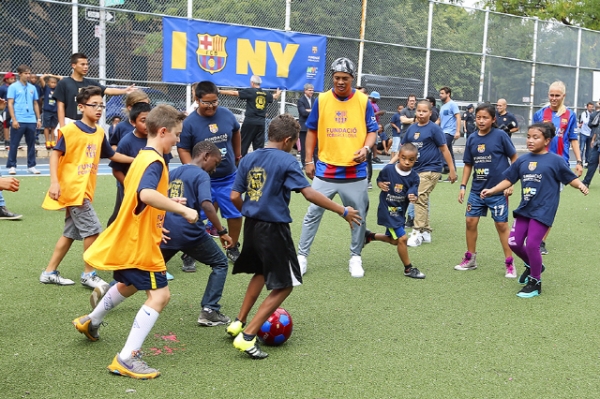전 바르셀로나 스타 선수 호나우지뉴가 2016년 9월 브롱크스에 위치한 뉴욕 시 공립 학교에서 아이들과 함께 축구를 하고 있다.