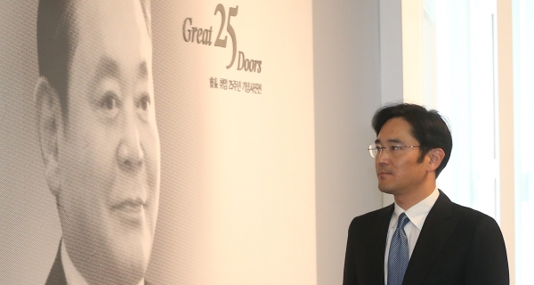 [사진=서울경제] 지난 2012년 이건희 회장 취임 25주년 기념식에 참석한 이재용 당시 삼성전자 사장이 아버지의 사진을 바라보고 있다.