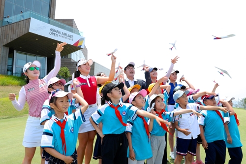 [사진=아시아나항공] 3일 중국 산둥성 웨이하이 포인트 호텔 & 골프 리조트에서 열린 '아름다운 버디 기부금' 행사에 참여한 선수들과 학생, 아시아나항공 관계자가 타산소학교 관계자와 함께 종이비행기를 날리고 있다.