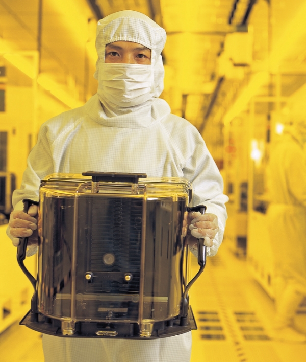 한 엔지니어가 대만 신주에 소재한 TSMC의 ‘위탁생산’ 시설에서 실리콘 웨이퍼를 옮기고 있다. 사진=포춘US