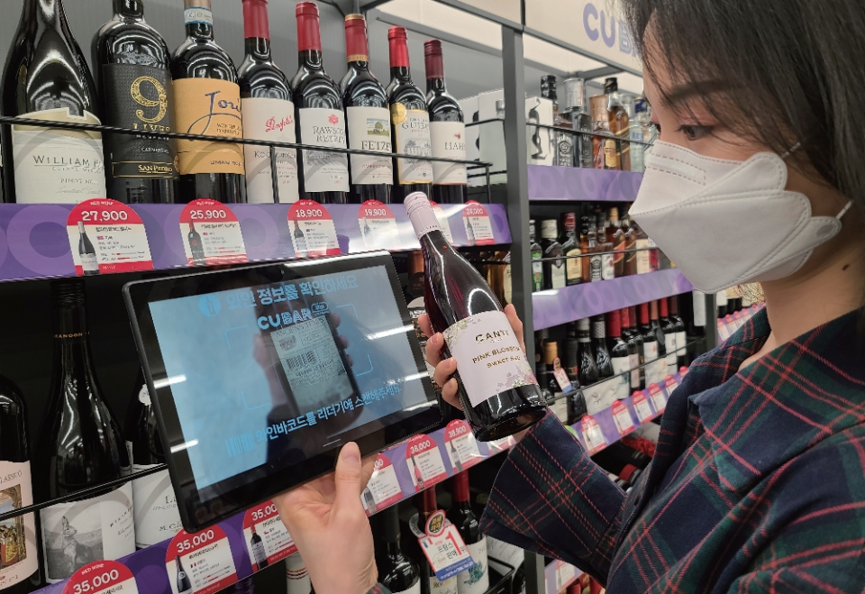 CU 편의점 와인 특화매대에서 한 소비자가 와인을 살펴보고 있다. 사진=BGF리테일 제공