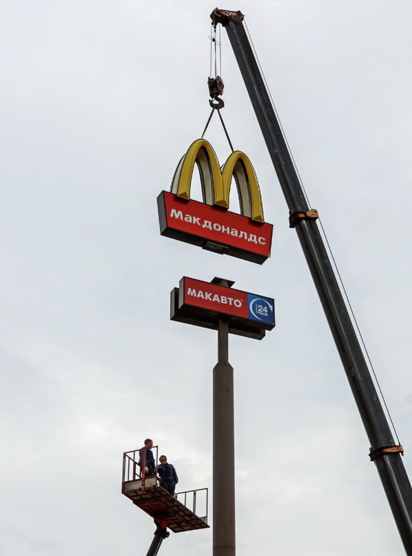 작업자들이 지난 6월 러시아 킨기세프의 한 매장에서 맥도날드 로고간판을 떼어내고 있다. {Anton Vaganov - Reuters]